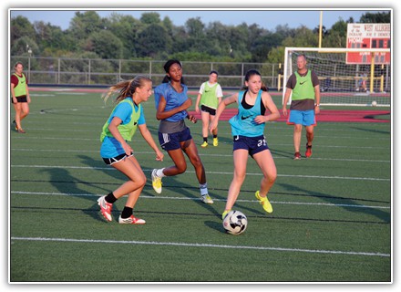 Girls soccer head coach Dave Tissue watches as incoming freshman Courtney Hurey attempts to shake off a defender and go in for a score. The junior varsity team that Tissue started when he became head coach is helping acclimate younger players to varsity play. PHOTO BY G. PAUL DEBOR